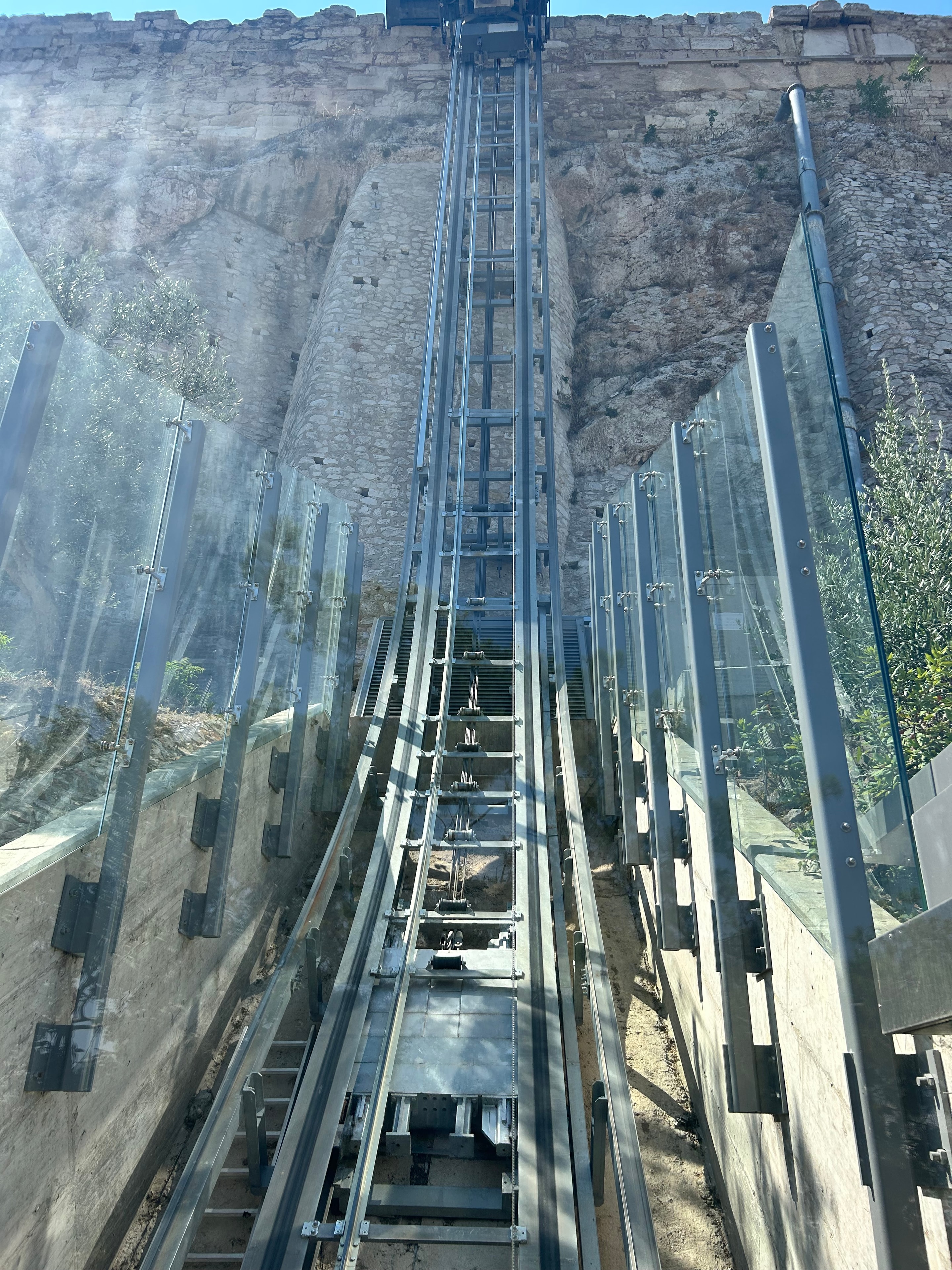 The glass-and-steel accessibility elevator at the Acropolis hill